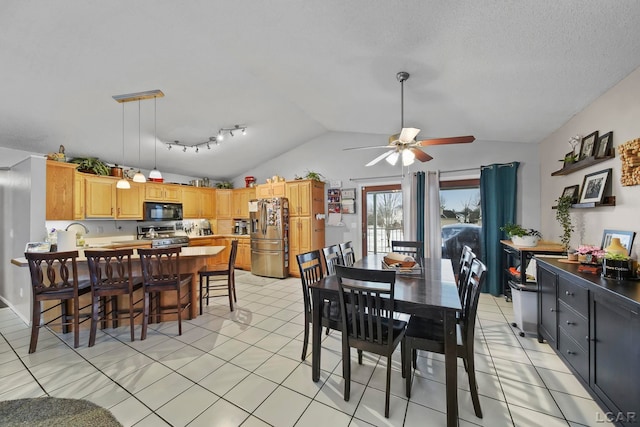 dining area featuring ceiling fan, light tile patterned floors, and lofted ceiling