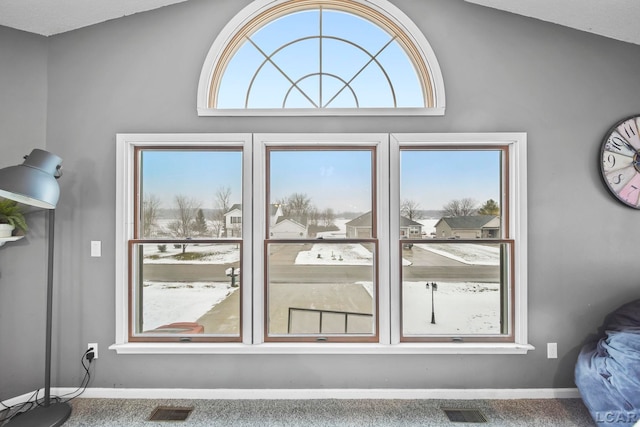 doorway to outside with carpet floors, plenty of natural light, and vaulted ceiling