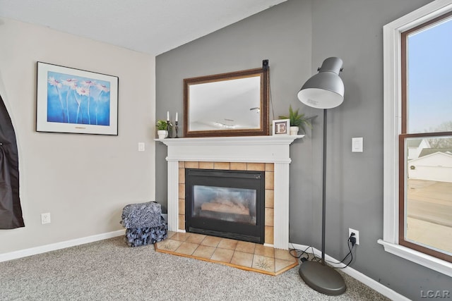 carpeted living room with a tile fireplace, lofted ceiling, and a healthy amount of sunlight