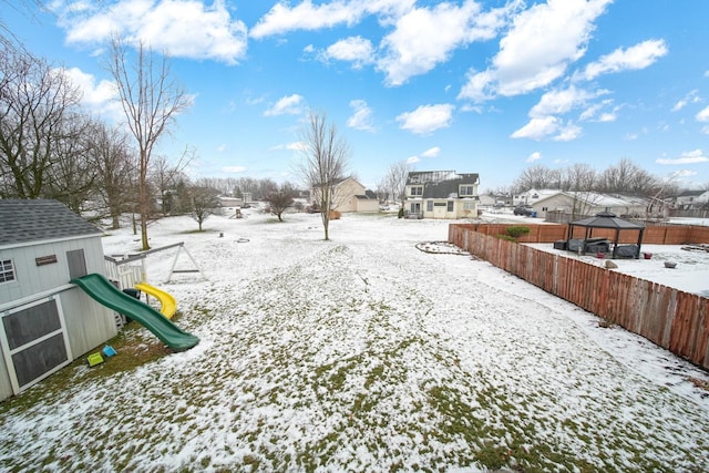 yard layered in snow featuring a playground