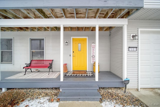 property entrance with covered porch and a garage