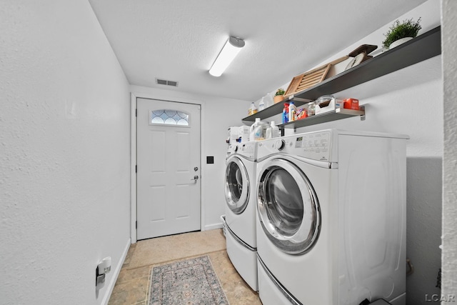 laundry area with a textured ceiling and washer and clothes dryer