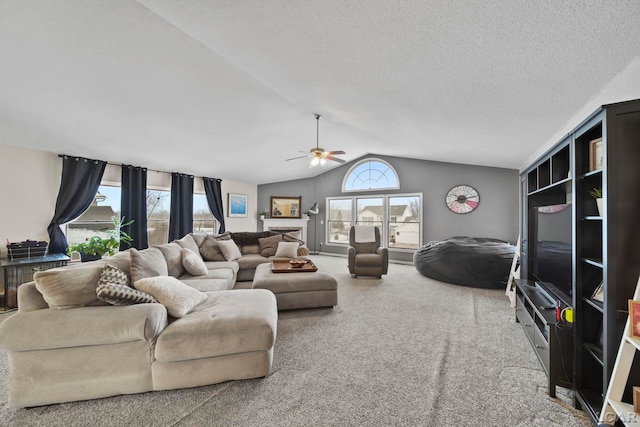 living room with lofted ceiling, a textured ceiling, carpet, and ceiling fan