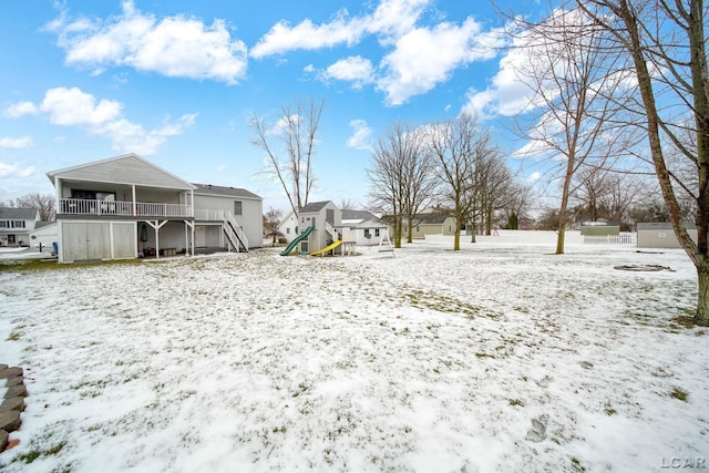 snowy yard featuring a playground