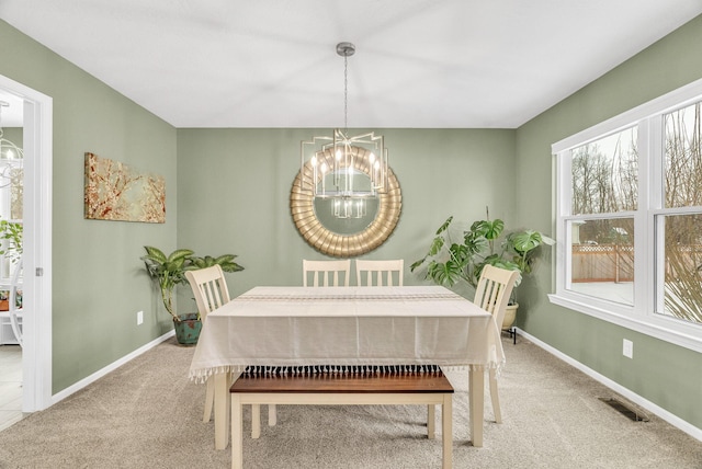 carpeted dining room featuring a notable chandelier