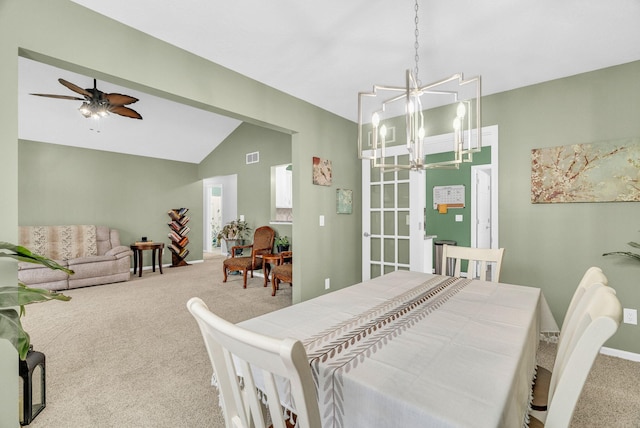 carpeted dining area featuring ceiling fan with notable chandelier and vaulted ceiling