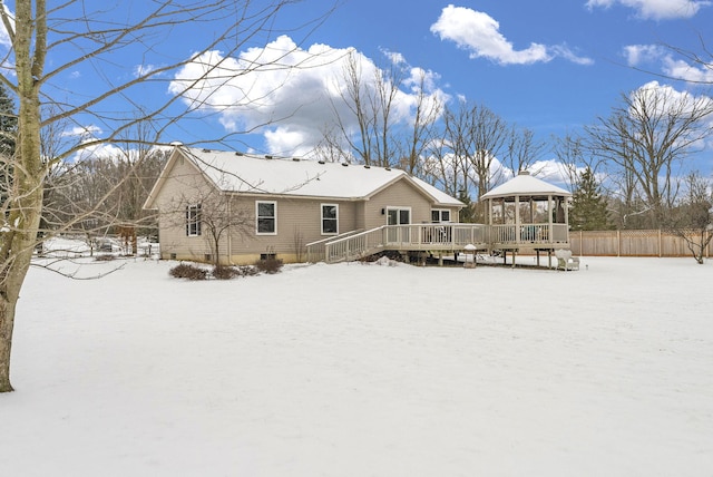 snow covered back of property featuring a deck and a gazebo