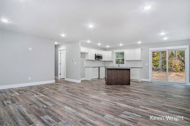 kitchen featuring decorative backsplash, hardwood / wood-style flooring, white cabinets, and a kitchen island