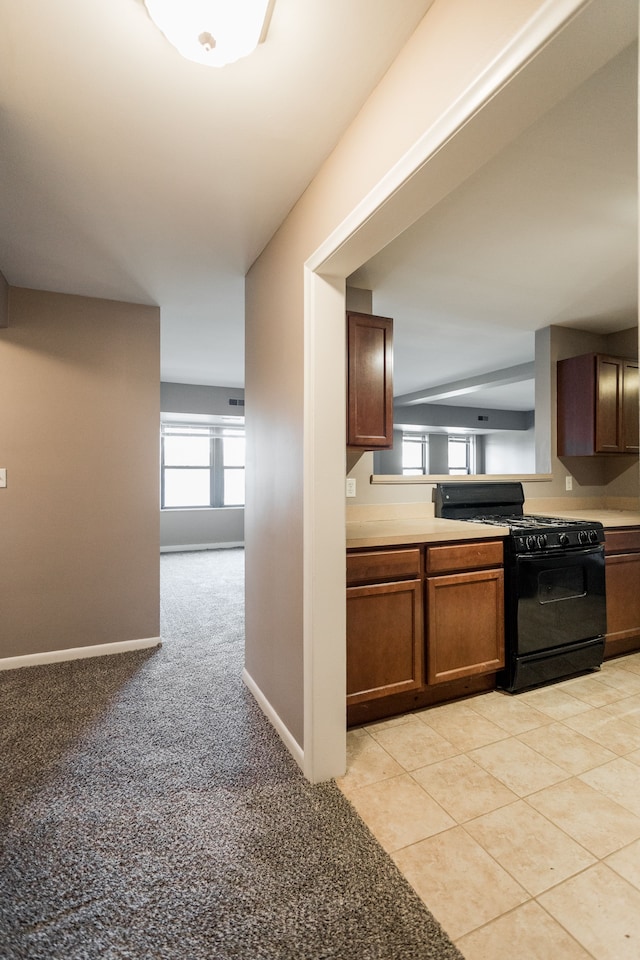 kitchen with black range with gas stovetop and light carpet