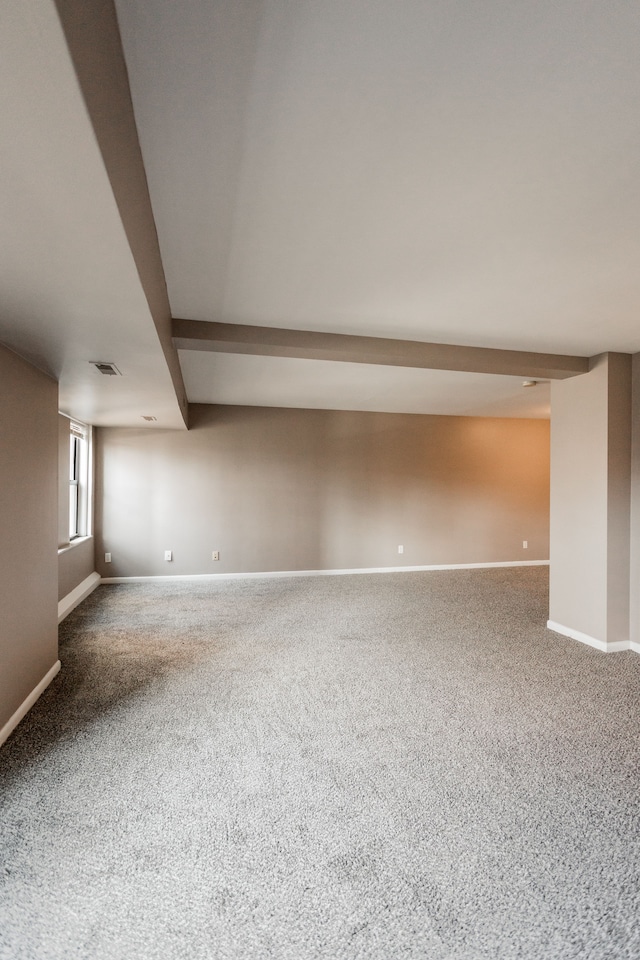 carpeted spare room with beam ceiling