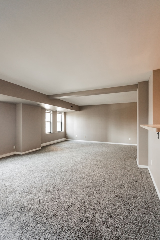 unfurnished room featuring beamed ceiling and carpet floors