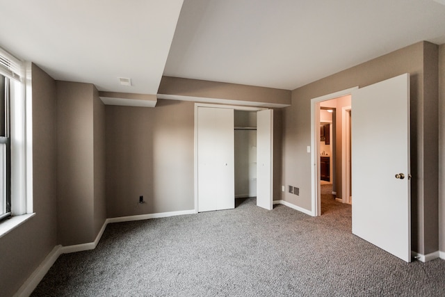 unfurnished bedroom with carpet flooring and a closet