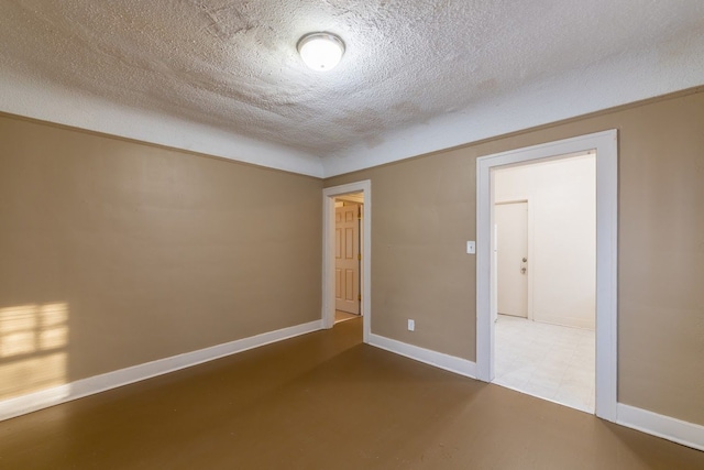 spare room with concrete floors and a textured ceiling