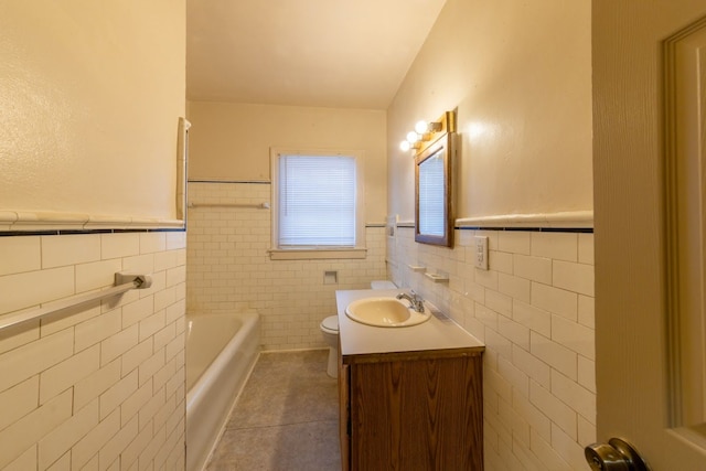 bathroom featuring tile patterned floors, vanity, a tub, tile walls, and toilet