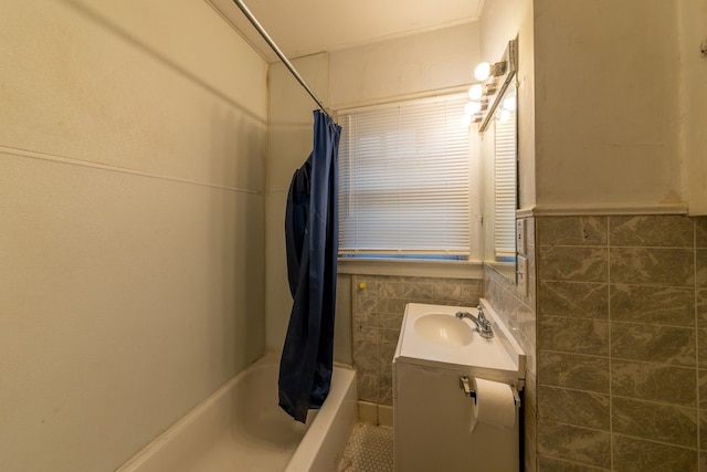 bathroom featuring vanity, tile walls, and shower / bathtub combination with curtain