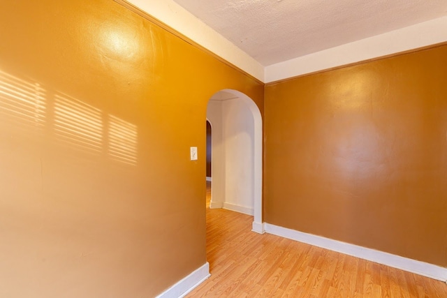 corridor featuring a textured ceiling and wood-type flooring