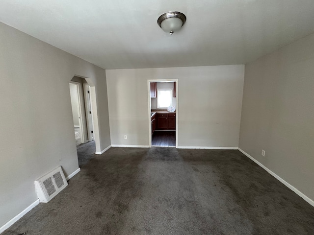 empty room featuring dark colored carpet