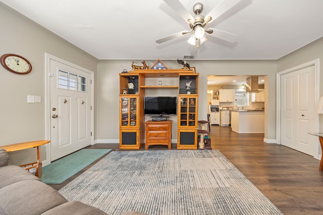 living room with dark wood-type flooring and ceiling fan