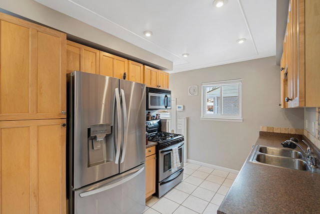 kitchen with light brown cabinetry, sink, light tile patterned floors, and stainless steel appliances