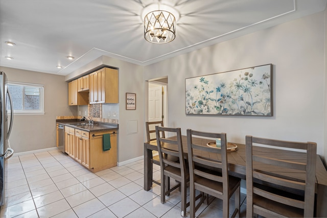 kitchen featuring light tile patterned flooring, appliances with stainless steel finishes, sink, a chandelier, and light brown cabinets