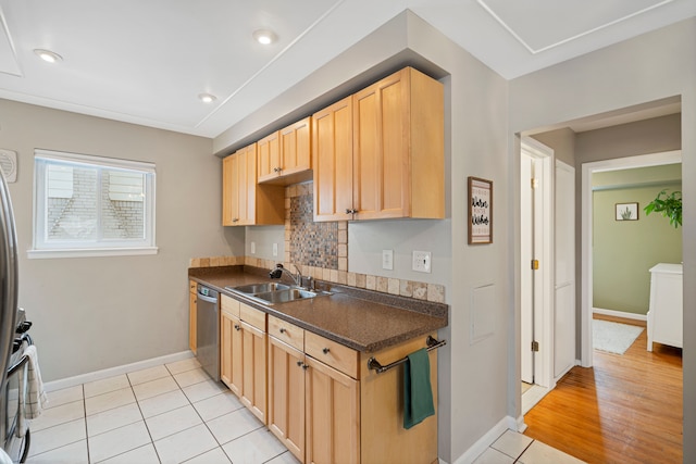 kitchen featuring sink, light tile patterned floors, dishwasher, backsplash, and light brown cabinetry