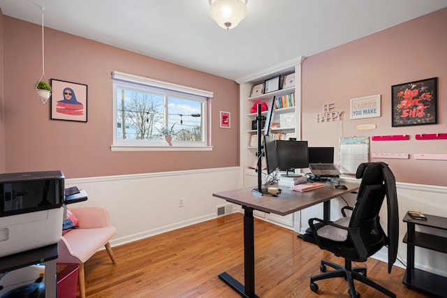 office with hardwood / wood-style flooring and built in features