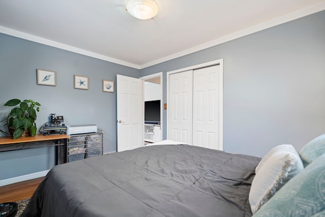 bedroom with crown molding, wood-type flooring, and a closet