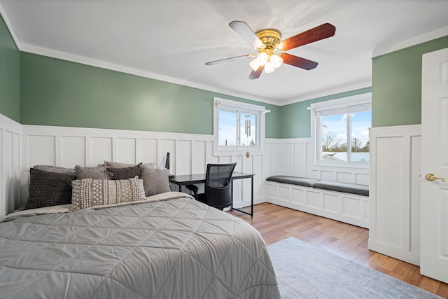 bedroom with multiple windows, crown molding, ceiling fan, and light hardwood / wood-style flooring