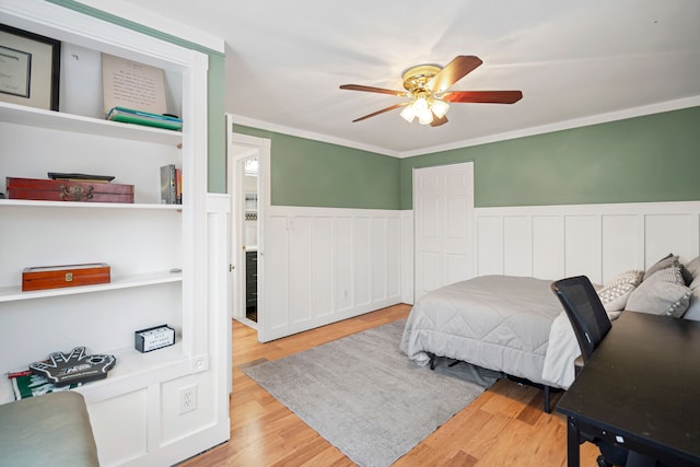 bedroom featuring crown molding, a closet, ceiling fan, and light wood-type flooring