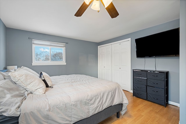 bedroom with light hardwood / wood-style flooring, a closet, and ceiling fan