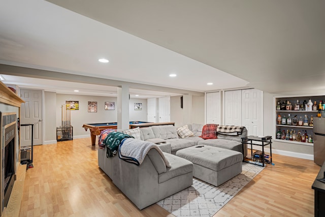 living room with pool table, light hardwood / wood-style flooring, and built in shelves