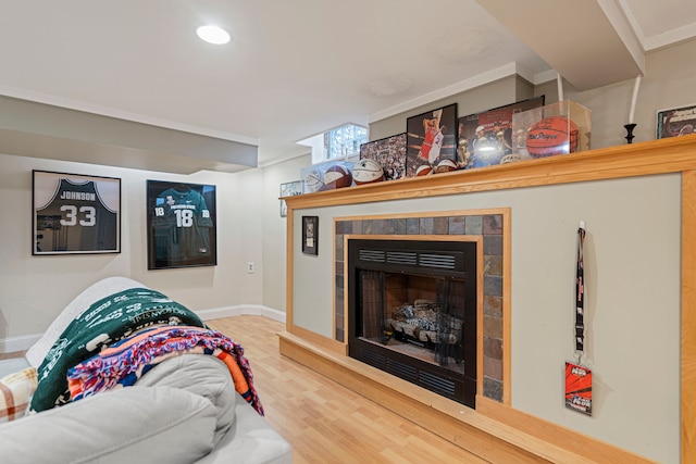 living room featuring a tiled fireplace and wood-type flooring