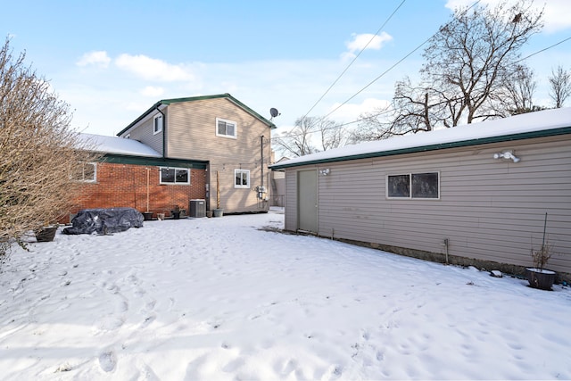 snow covered rear of property with central AC unit