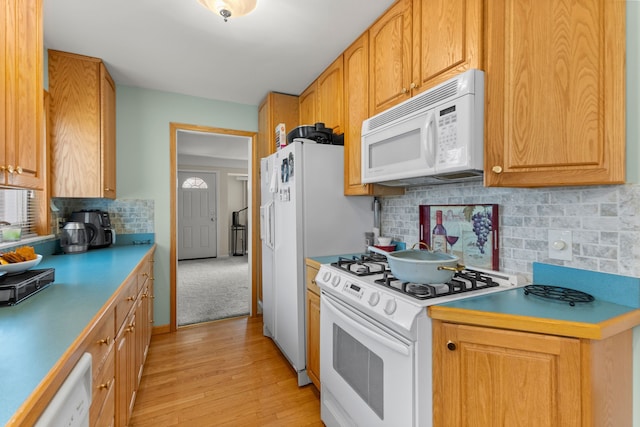 kitchen with backsplash, white appliances, and light hardwood / wood-style flooring