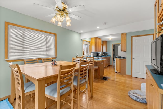 dining space with light hardwood / wood-style floors and ceiling fan