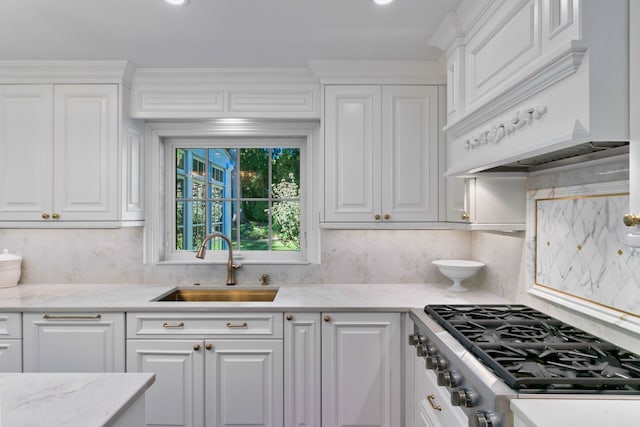 kitchen featuring stainless steel gas stovetop, custom exhaust hood, decorative backsplash, sink, and white cabinetry