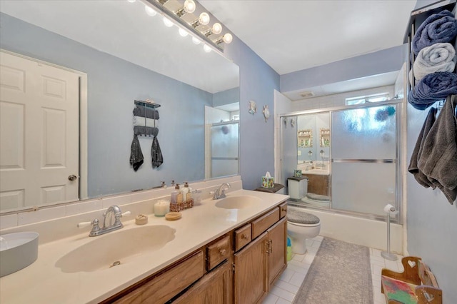 full bathroom with toilet, combined bath / shower with glass door, tile patterned floors, and vanity