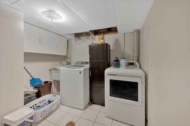 clothes washing area featuring light tile patterned flooring and washer and clothes dryer