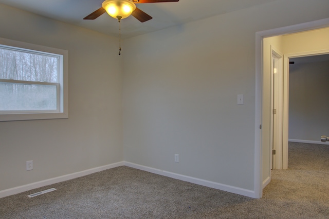 carpeted spare room featuring ceiling fan