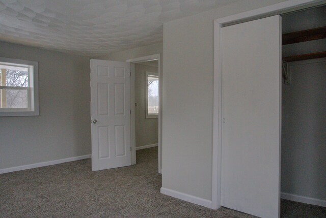 unfurnished bedroom featuring carpet and a closet