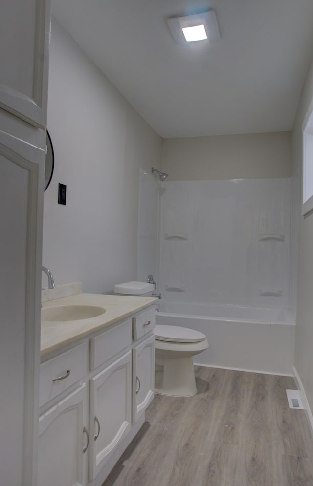 full bathroom with toilet, wood-type flooring, shower / washtub combination, and vanity