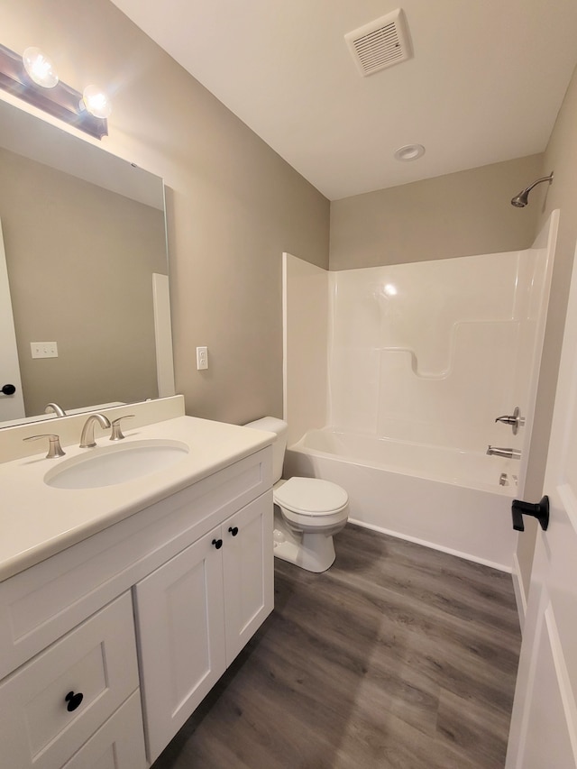 full bathroom featuring hardwood / wood-style flooring, washtub / shower combination, toilet, and vanity