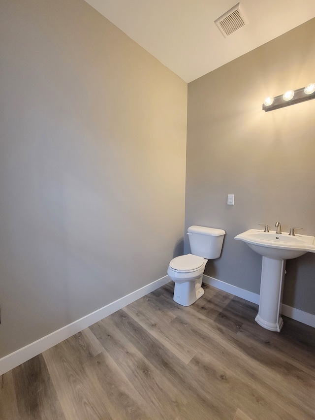 bathroom featuring toilet, hardwood / wood-style flooring, and sink