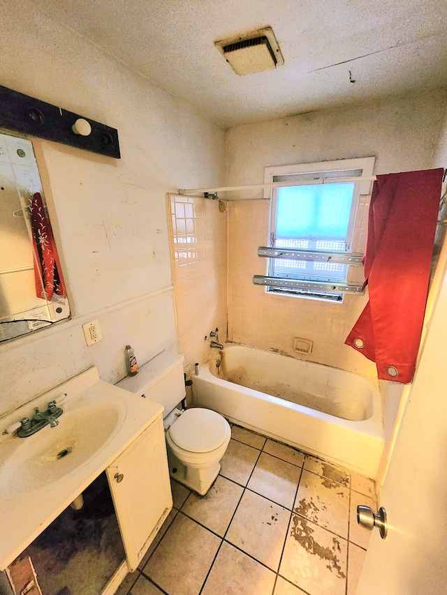 full bathroom with vanity, a textured ceiling, tile patterned floors, toilet, and tiled shower / bath