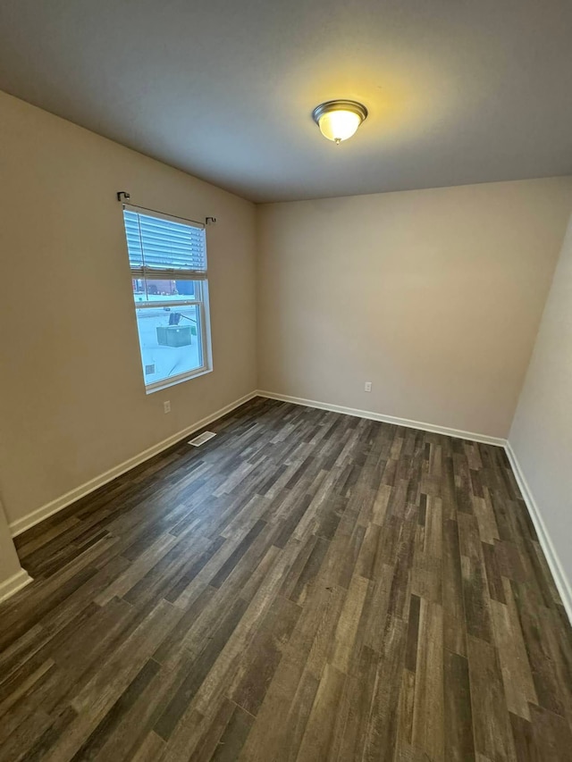 unfurnished room featuring dark wood-type flooring