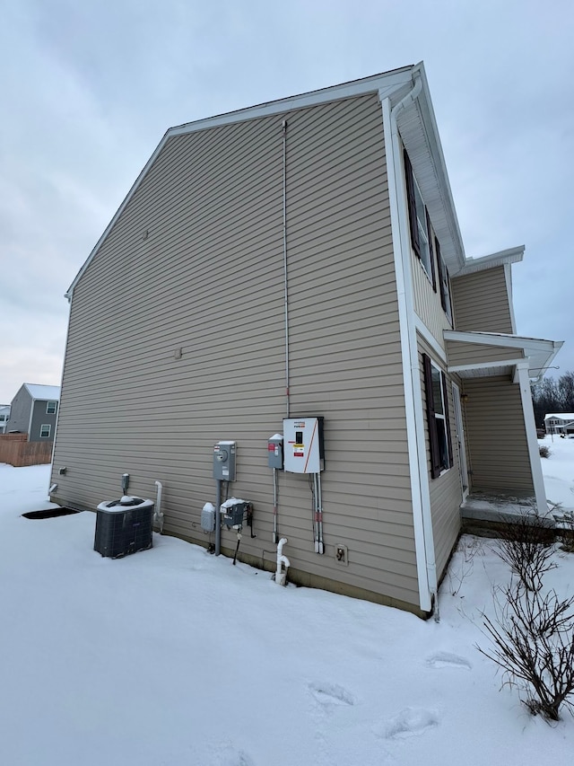 view of snow covered exterior featuring central air condition unit