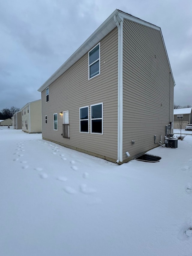 snow covered property with central air condition unit