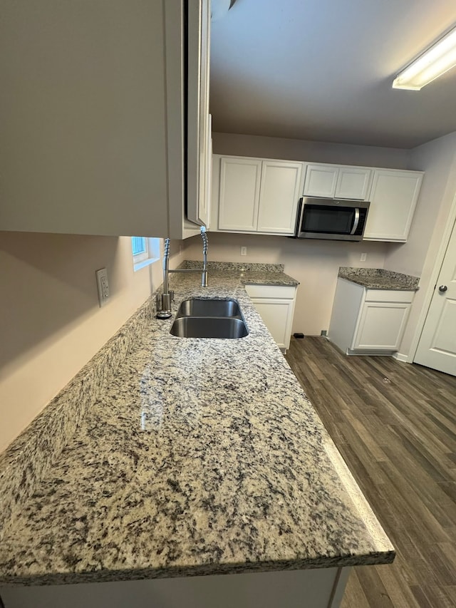 kitchen featuring white cabinets, dark hardwood / wood-style flooring, sink, and stone countertops