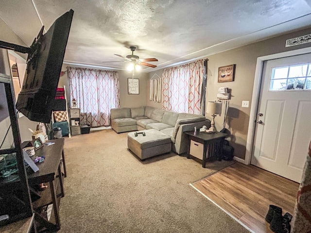 carpeted living room with a textured ceiling and ceiling fan