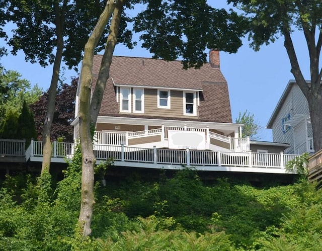 1511 Bernice Ave, Saint Joseph, MI 49085 - rear view of property with a chimney, a wooden deck, and a shingled roof